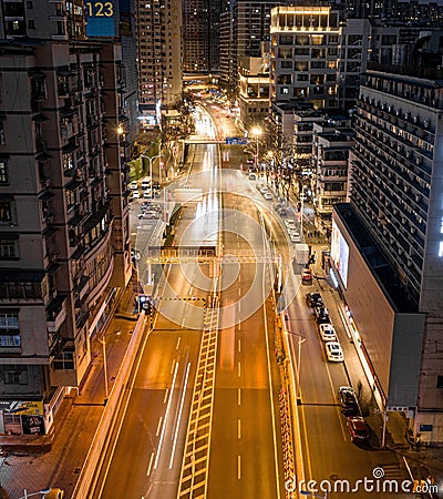 Aerial photo of a winding road leads to a large metropolitan cityscape of Wuhan night scene, China. Editorial Stock Photo