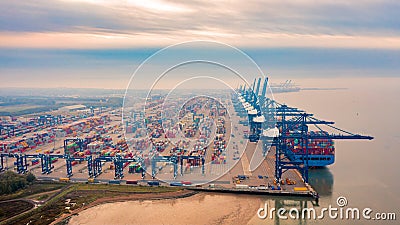 Aerial photograph of Felixstowe container port, rows of stacked multicoloured shipping containers and blue loading gantries Stock Photo