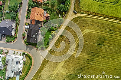 Aerial photograph of two houses on a path behind a field, taken with the drone Stock Photo