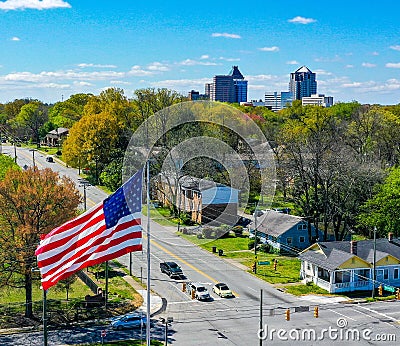 Aerial shot of the American flag and Greensboro, NC skyline on the horizon on a spring day Stock Photo