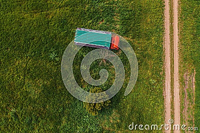 Aerial shot of apiary truck and trailer with beehive boxes in field in spring, drone pov Stock Photo