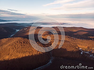 Aerial shot of the Bukk Mountains in winter, dense hilly landscape, Bukk National Park at sunrise Stock Photo