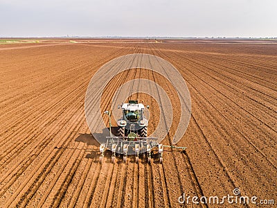 Aerial shot of a farmer seeding, sowing crops at field. Stock Photo
