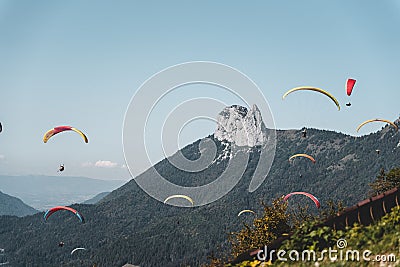 Aerial shot of a group of people paragliding in the sky above a majestic mountain peak Stock Photo