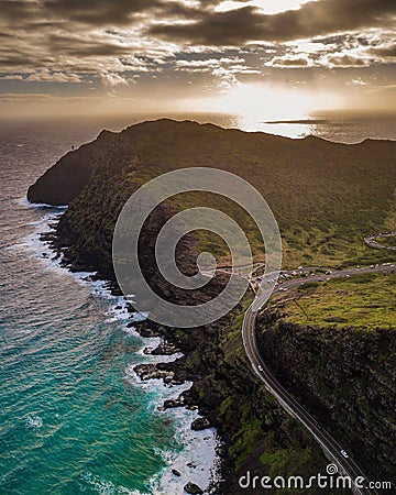 Aerial shot of mesmerizing Oahu island coastline with sun rays shining on the sea in the background Stock Photo