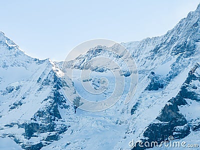 An aerial shot shows Verbier, Switzerland's snowy landscape, ski tracks, a peak Stock Photo