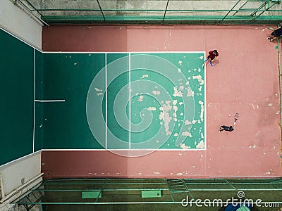 Aerial shot some people playing tennis in an old playground against the wall called fronton. Editorial Stock Photo