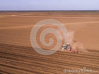 Aerial shot of a tractor cultivating field at spring Stock Photo