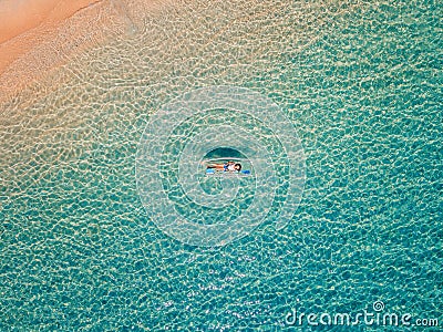 Aerial shot of woman relaxing in a kayak Summer seascape beach and blue sea water Top view from drone Stock Photo