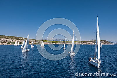 Aerial shot of the yacht race, a sailing regatta, intense competition, a lot of white sails, island is on background Editorial Stock Photo