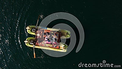 Aerial top-down close up on traditional Uros boat made of Totora plant with tourists on board Stock Photo