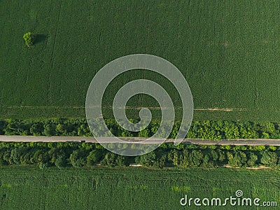 Aerial top down green field with crossing road Stock Photo