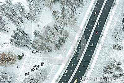 Aerial top down image of city suburb area with trees under snow and road Stock Photo
