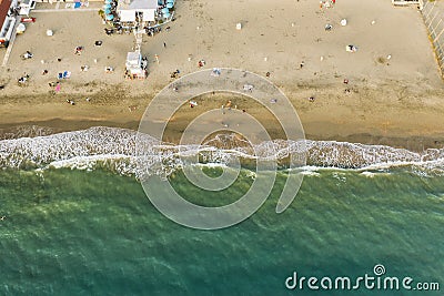 Aerial top down view of Italian resort beach with sand and foaming sea waves at sunset. Ostia Lido near Rome, Italy Stock Photo