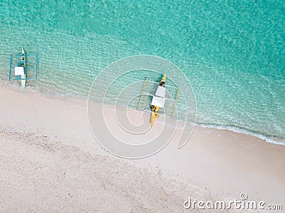 Aerial top down view of white sand beach with a traditional philippine boats beached on it Stock Photo