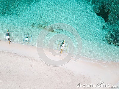 Aerial top down view of white sand beach with a traditional philippine boats beached on it Stock Photo