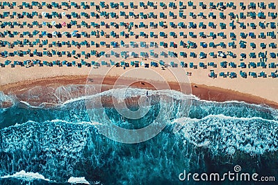 Aerial top view on the beach. Umbrellas, sand and sea waves Stock Photo
