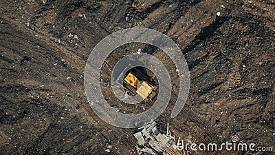 Aerial top view of a construction site or country dump with yellow excavator or bulldozer, heavy equipment, drone photo Stock Photo
