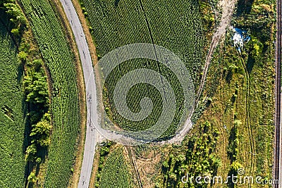 Aerial top view of curve country road among green fields in summer day Stock Photo