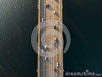 Aerial or top view from drone of concrete bridge with asphalt road or highway over big river with city car traffic Stock Photo