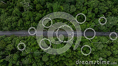 Aerial top view of green electric vehicle car driving over straight forest road, EV car electric vihicle car on forest road with Stock Photo