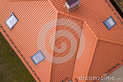 Aerial top view of house metal shingle roof, brick chimneys and small plastic attic windows. Roofing, repair and renovation work Stock Photo