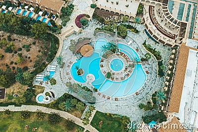 Aerial top view of little hotel with swimming pool, sunbeds and palms from above, tropical holiday resort, mediterranean Stock Photo