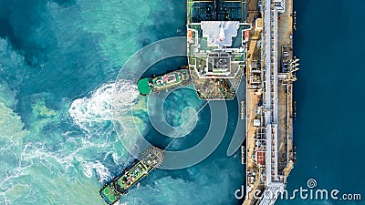 Aerial top view oil tanker ship at terminal industrial port tugboat drag crude oil tanker ship park to port for transfer crude oil Stock Photo