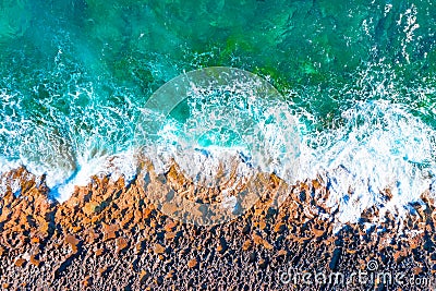 Aerial top view of sea waves hitting rocks on the beach Stock Photo