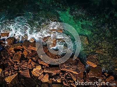 Aerial top view of sea waves hitting rocks on the beach with turquoise sea water. Amazing rock cliff seascape in the Portuguese co Stock Photo