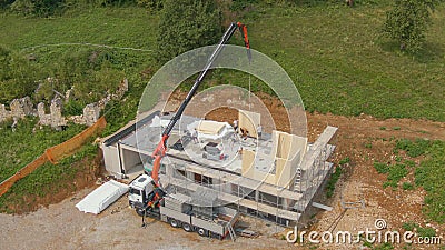 AERIAL: Truck boom operator helps contractors working on building CLT house. Stock Photo