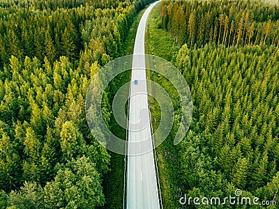 Aerial view from above of country road through the green summer forest in summer Finland. Stock Photo