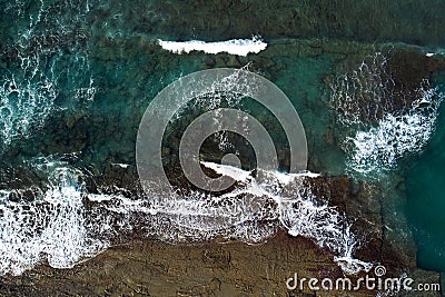 Aerial view from above on sea vawes , waves and foam crashing on the beach forming beautiful textures, patterns Stock Photo