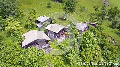 Aerial view, Alpine chalets on Green Mountain slope under blue sky. Austria Alps Stock Photo