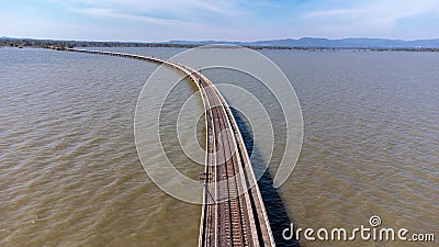 Aerial view of an amazing travel train parked on a floating railway bridge over the water of the lake in Pa Sak Jolasid dam with b Stock Photo