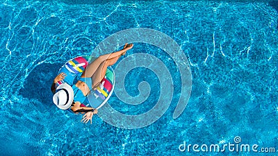 Aerial view of beautiful girl in swimming pool from above, swim on inflatable ring donut and has fun in water Stock Photo