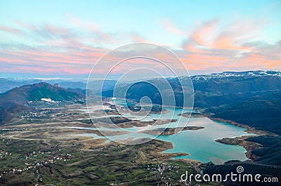 Aerial view of beautiful green lake and islands surrounded by mountains. Autumn landscape at evening. Large artificially formed la Stock Photo