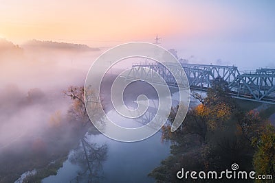 Aerial view of beautiful railroad bridge and river in fog in fall Stock Photo