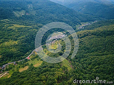 Aerial view of the beautiful wooded Carpathian mountains and small village, summer landscape Stock Photo