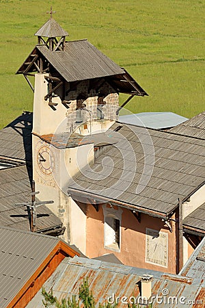 Aerial view of the bell tower of Saint Sebastien Church, with a Cross of Jesus Christ and a sundial, Ceillac Stock Photo