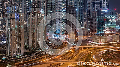 Aerial view on Dubai Marina with big highway intersection night timelapse and skyscrapers around, UAE Stock Photo