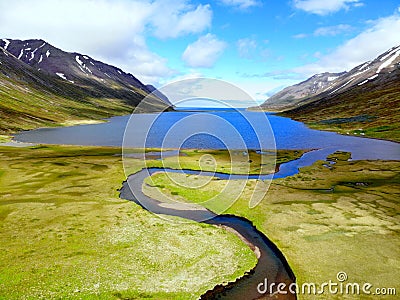 The aerial view of a blue creek flowing into the lake near Hedinsfjordur, Iceland Stock Photo