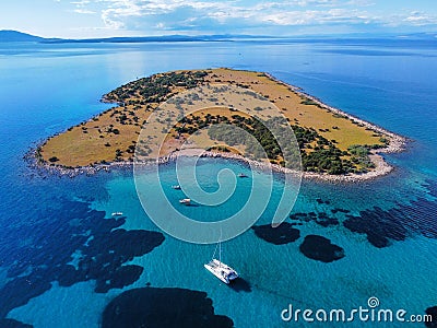 Aerial view of boats getting closer to a small island in the blue sea Stock Photo