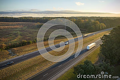 Aerial view of busy american highway with fast moving traffic surrounded by fall forest trees. Interstate transportation Stock Photo