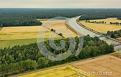 Aerial view of a canal that runs through fields, meadows and arable land in the flat landscape of northern Germany Stock Photo