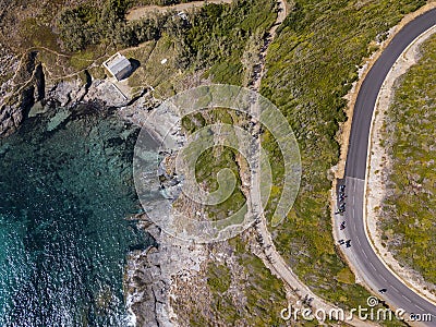 Aerial view of the coast of Corsica, winding roads and coves. Motorcyclists parked on the edge of a road. France Stock Photo