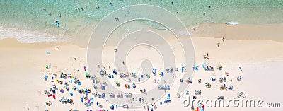 Aerial view crowded public beach with colourful umbrellas, Aerial view of sandy beach with tourists swimming in beautiful clear Stock Photo