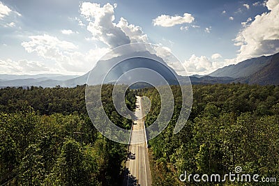 Aerial view of Doi Luang Chiang Dao mountain with straight road among the forest on bright day Stock Photo