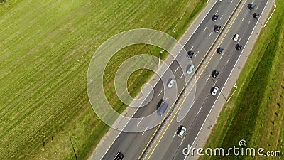Aerial view from a drone on an asphalt road, a highway divided by a zone with cars and other transport. The view from the bird`s eye view on a wide highway with stock footage Aerial view from a drone on an asphalt road, a highway divided by a zone with cars and other transport. The view from the bird`s eye view on a wide highway with stock footage