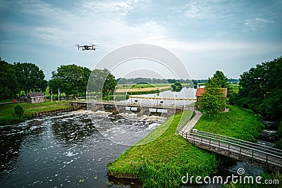 An aerial view with drone in the background above a weir in the river Vecht in the Netherlands. Downstream Stock Photo
